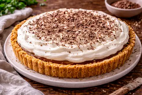 Британский десерт с песочной основой, карамельной сгущёнкой, бананами и воздушными взбитыми сливками.