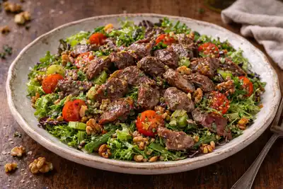 Тёплый французский салат с утиными желудками, зеленью и орехами в горчичной заправке.