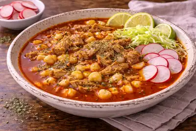 Традиционный мексиканский мясной суп с свининой, кукурузой хомини и насыщенным чили-бульоном.