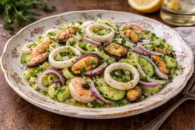 Лёгкий салат с кальмарами, мидиями и свежими овощами в лимонно-оливковой заправке.